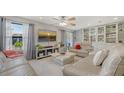 Bright living room featuring comfortable sofas, a ceiling fan, and a large window offering neighborhood views at 6836 Midnight Pass Rd # 6836, Sarasota, FL 34242