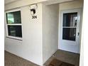 Condo entrance featuring a storm door, exterior light, and the unit number at 7201 29Th Avenue W Dr # 306, Bradenton, FL 34209