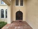 Arched front door is framed by brick patio, and windows in this elegant property at 7732 N Mobley Rd, Odessa, FL 33556
