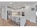Modern kitchen features an island, stainless steel appliances, and bright white cabinetry at 10724 Spring Tide Way, Parrish, FL 34219