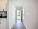 Bright hallway with neutral walls leading to the front door and offering a view of the kitchen at 11015 High Noon Trl, Parrish, FL 34219