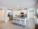 Modern kitchen featuring white cabinets, stainless steel appliances, granite countertops, and island with stool seating at 11015 High Noon Trl, Parrish, FL 34219