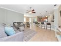 Open-concept living room leading to a kitchen bar, complete with tile flooring and comfortable seating arrangements at 11455 52Nd E Ct, Parrish, FL 34219