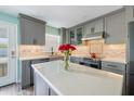 Modern kitchen featuring gray cabinets, quartz countertops, stainless steel appliances, and an island at 116 Vista Hermosa Cir # 204C, Sarasota, FL 34242