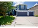 Charming two-story blue home with a three car garage and well maintained landscaping at 12214 Streambed Dr, Riverview, FL 33579