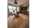 Bright kitchen nook featuring travertine tile, modern table and chairs, and serene backyard views at 14432 Mcclellan Ave, Port Charlotte, FL 33953