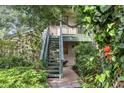 Two-story home with a wooden staircase and a balcony surrounded by lush, mature greenery at 1609 Bayhouse Point Dr # 232, Sarasota, FL 34231