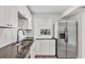 Bright kitchen featuring stainless steel appliances, dark countertops, and white cabinets at 1609 Bayhouse Point Dr # 232, Sarasota, FL 34231