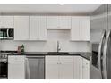 Updated kitchen with stainless steel appliances, granite countertops, and white cabinets at 1609 Bayhouse Point Dr # 232, Sarasota, FL 34231