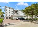 Modern multi-story building featuring assigned parking, brick driveway and manicured landscaping at 174 Golden Gate Pt # 21, Sarasota, FL 34236