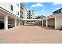 Open parking area showcases brick pavers and covered parking at 174 Golden Gate Pt # 21, Sarasota, FL 34236