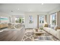 Bright living room featuring a stylish rug, a comfortable white sofa, and an adjacent dining area at 204 Eagleston Ln, Lakewood Ranch, FL 34240