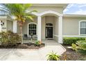Charming front entrance with decorative columns, landscaping, and covered porch at 2808 124Th E Ave, Parrish, FL 34219