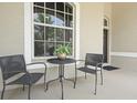 Close up of a cozy front porch seating area with an ornate, leaded glass window at 2808 124Th E Ave, Parrish, FL 34219
