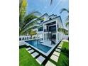 Stunning backyard showcasing a modern pool, spiral staircase, and lush tropical landscaping at 2809 Avenue E, Holmes Beach, FL 34217
