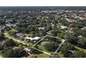 Aerial view showcases the home's location in a desirable neighborhood near a lake and wooded areas at 3010 E Forest Lake Dr, Sarasota, FL 34232