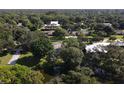 Overhead view of a wooded property with mature trees, surrounded by a tranquil pond at 3010 E Forest Lake Dr, Sarasota, FL 34232