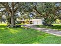 Well maintained home with mature trees and a long driveway leading to the attached garages at 3010 E Forest Lake Dr, Sarasota, FL 34232