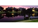 Scenic twilight view of the condo buildings with palm trees reflecting in the tranquil lake at 3430 77Th W St # 103, Bradenton, FL 34209