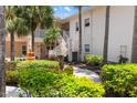 Exterior view of a condo complex with walkways, stairs, lush landscaping, and a fountain, creating a welcoming environment at 4244 Central Sarasota Pkwy # 726, Sarasota, FL 34238