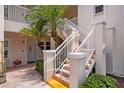 Close-up of condo building exterior featuring well-maintained white stairs and walkway leading to units on the second level at 4244 Central Sarasota Pkwy # 726, Sarasota, FL 34238