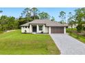 Beautiful single-story home with a well-manicured lawn, paver driveway, and modern design at 4661 Forlano Cir, North Port, FL 34291