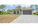 Attractive single-story home with a modern design, manicured lawn, and a grey brick driveway at 4661 Forlano Cir, North Port, FL 34291