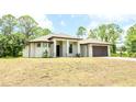 Charming one-story home featuring a modern style, a two-car garage and a landscaped lawn at 4661 Forlano Cir, North Port, FL 34291