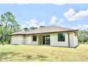 A view of the rear exterior of a one-story home with sliding glass doors to the backyard at 4661 Forlano Cir, North Port, FL 34291