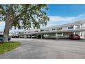 Exterior view of condo building showing carports and ample parking space and mature trees at 4745 Independence Dr # 4745, Bradenton, FL 34210