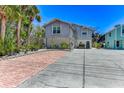 Two-story home with lush landscaping, a brick-lined driveway, and plenty of parking at 5385 Avenida Del Mare, Sarasota, FL 34242