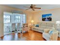 Bright living room featuring wood floors, modern ceiling fan, stylish seating, and view into sunroom at 5385 Avenida Del Mare, Sarasota, FL 34242