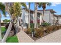 Attractive condo building featuring lush landscaping, brick paved entrance and stairs on a sunny day at 6204 Midnight Pass Rd # 201, Sarasota, FL 34242