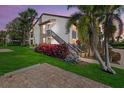 Condo exterior with attractive landscaping, green lawn, and brick paver parking area at 6204 Midnight Pass Rd # 201, Sarasota, FL 34242