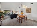 Open-concept living room featuring neutral carpet, vaulted ceilings, and a view to the balcony at 6204 Midnight Pass Rd # 201, Sarasota, FL 34242