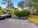 A parking area featuring one dark-colored car adjacent to a lush, green landscaped area in front of the residence at 635 N Jefferson Ave # 635, Sarasota, FL 34237