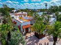 Beautiful two-story home with lush tropical landscaping, a red tile roof and brick paved driveway at 681 Avenida De Mayo, Sarasota, FL 34242