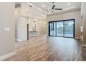 Spacious living room with wood flooring and a sliding glass door with a view of the pool at 7152 Bougainvillea St, Englewood, FL 34224