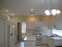 Bright kitchen with white cabinets, appliances, and tile flooring at 12301 Mosswood Pl, Lakewood Ranch, FL 34202