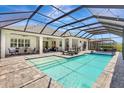 Inviting screened-in pool area with stylish lounge chairs and string lights for evening relaxation at 13918 Old Creek Ct, Parrish, FL 34219