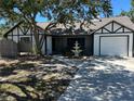 Charming exterior featuring a white-painted home, one car garage and mature trees at 1500 Crest Dr, Englewood, FL 34223