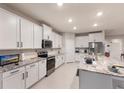 Modern kitchen features white cabinets, stainless steel appliances, and granite countertops on a large island at 16807 Barnwood Pl, Bradenton, FL 34211