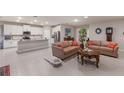 Open-concept living room and kitchen, showcasing tile floors, stainless steel appliances, and two cozy sofas at 16807 Barnwood Pl, Bradenton, FL 34211