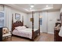 Comfortable main bedroom featuring wood floors, a tray ceiling, and serene natural lighting at 16807 Barnwood Pl, Bradenton, FL 34211