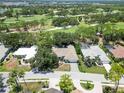 An aerial view of a single-story home surrounded by a golf course and mature trees at 2067 Tocobaga Ln, Nokomis, FL 34275