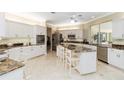 An open kitchen with white cabinets, stainless steel appliances, and a large center island with seating at 2067 Tocobaga Ln, Nokomis, FL 34275