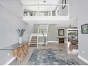 Bright foyer with natural light, wood stairs, and a modern open design for a welcoming entrance at 2100 Oyster Creek Dr, Englewood, FL 34224