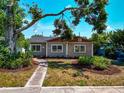 Inviting single-story home with a neatly landscaped front yard, walkway, and mature tree in view at 2620 8Th N Ave, St Petersburg, FL 33713
