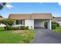Charming villa with a covered carport and lush front yard landscaping at 2733 Riverbluff Pl # V57, Sarasota, FL 34231