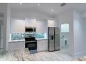 Modern kitchen featuring granite countertops, stainless steel appliances, and stylish backsplash at 2881 Pope St, North Port, FL 34287